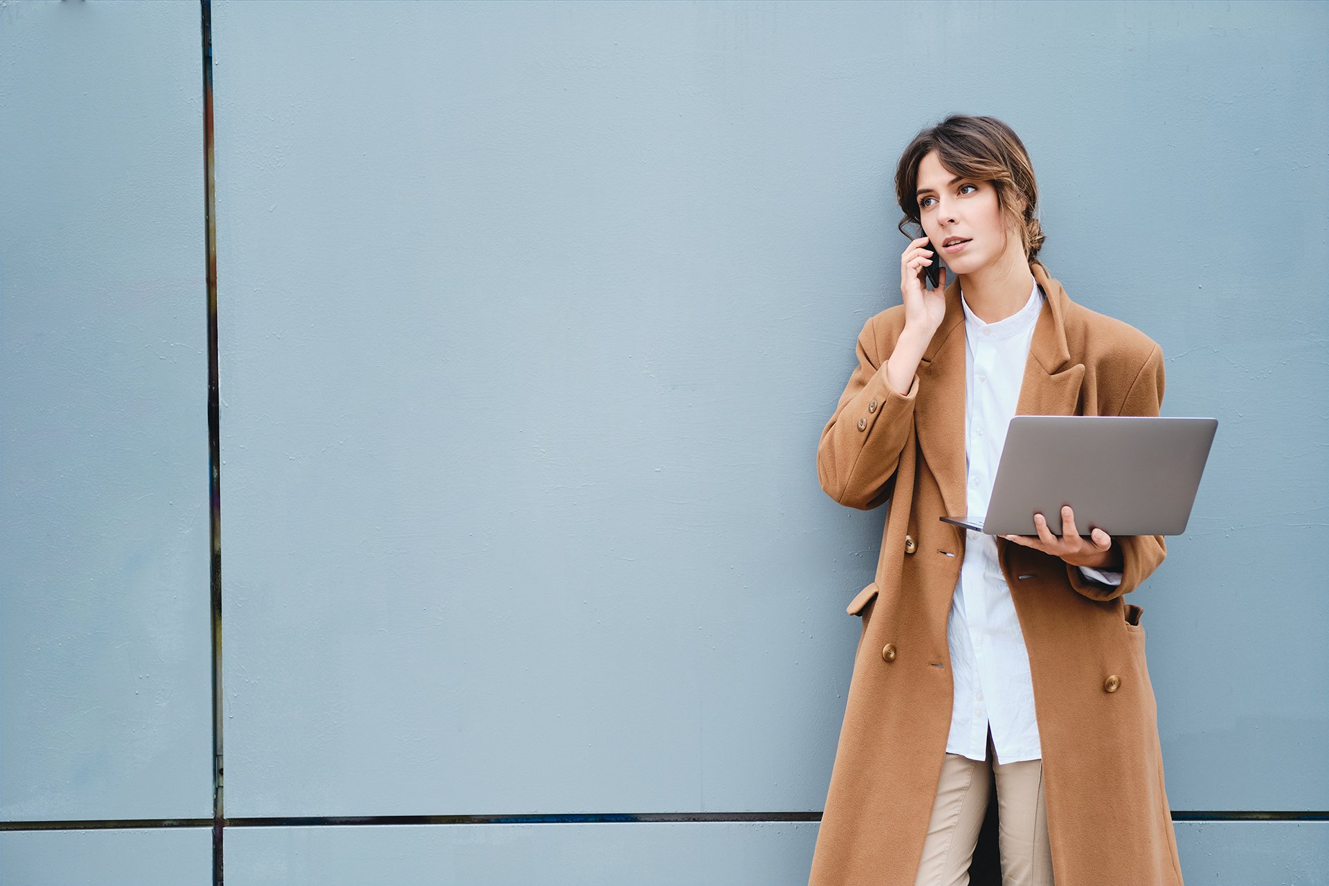 woman working on phone and laptop